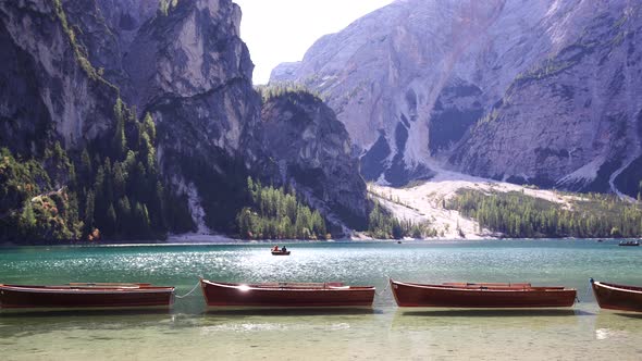 Boats Stand on the Shore of the Lago Di Braies Lake Against the Backdrop of Mountains alt