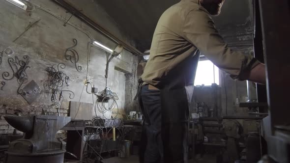 Blacksmith Making Decorative Element in Workshop alt