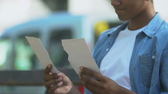 Broken-hearted Afro-American teen boy putting together two pieces of photo alt