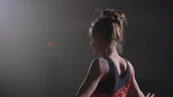 Young Female Gymnast is Standing on Floor in Sports Hall and Preparing to Start Her Performance alt