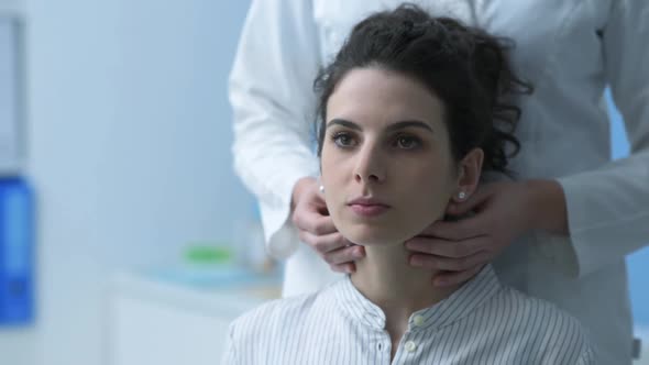 Doctor examining a patient and checking her neck