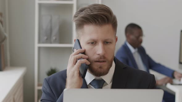 Trader Calling Investors and Working with Trading Platform om Laptop alt