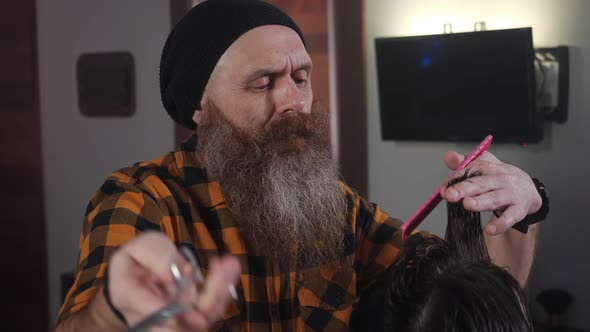 Adult Male Hairdresser Cuts a Strand of Hair To a Male Customer in the Salon alt