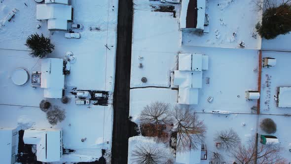 Top down view of winter roofs in residential small town during a winter day after snowfall alt