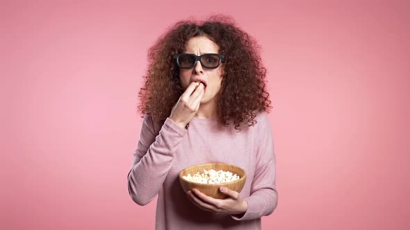Young Woman in 3d Glasses Watching Horror Movie, Eating Popcorn on Pink Studio alt