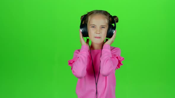 Baby Listens To the Music in the Headphones. Green Screen. Slow Motion alt