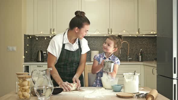 Little Daughter Helps Her Mother To Cook Some Dough. Fun and Rewarding Family Time alt