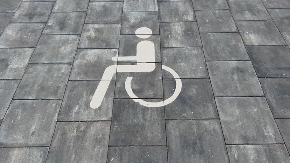 Large Disabled Parking Lot White Sign Over Brick Pavement alt