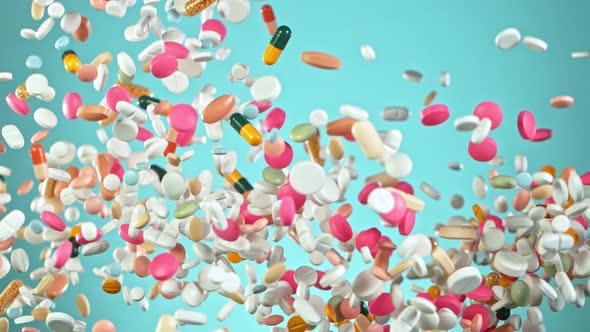 Super Slow Motion Shot of Flying Colorful Pills on Light Blue Background at 1000Fps alt
