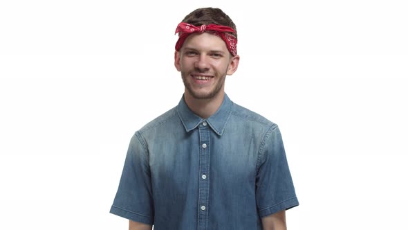 Waistup Shot of Attractive Bearded Male Hipster Wearing Red Bandana and Denim Shirt Starting to
