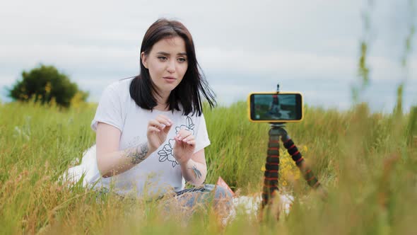 Young Stylish Girl Woman Blogger Influencer Creator Sits Outdoors in Front Mobile Phone on alt