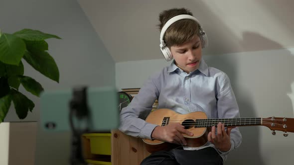 Boy Of Ten Sitting In The Nursery With Guitar In His Hands alt