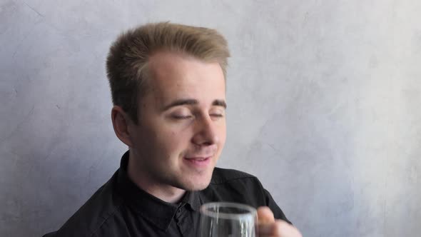 A Dreamy European Man is Sitting at the Window and Drinking Hot Tea the Sun is Shining Enjoying a alt