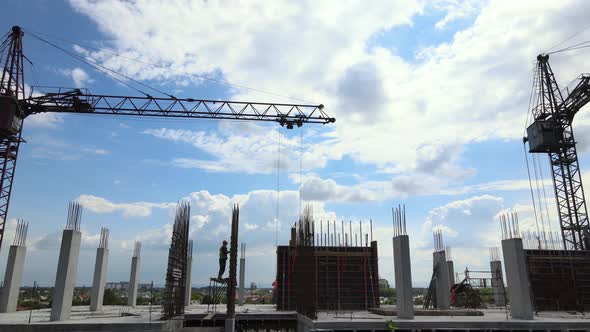 Tower Cranes and Workers at High Concrete Residential Building Under Construction alt
