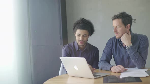 Man showing colleague something on computer alt