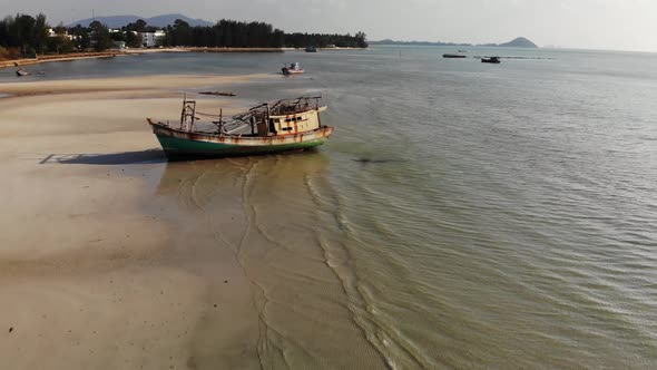 Fishing Ship on Sand Coast Near Water. Old Deserted Rusty Fishing Boat on Sand Shore Near Sea in alt