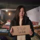 Portrait of a Sad Armenian Woman in a Large Bomb Shelter Holding a Sign
