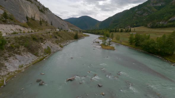 FPV Sports Drone Shot Picturesque Cloudscape Valley Natural Mountain River Water Stream and Highway alt