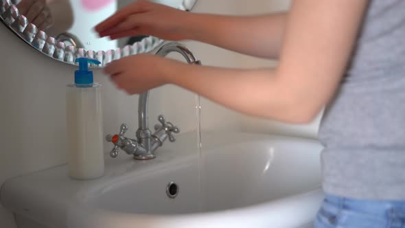 Woman Washes Her Hands with Liquid Soap in the Bathroom.