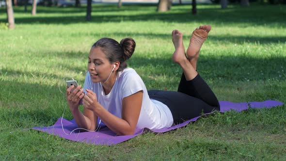 Girl with Headphones and with the Phone in Her Hand Laughing and Listening To Music alt