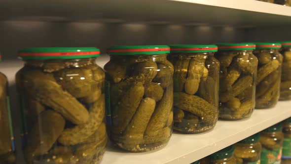 Pickled Cucumbers in Banks stand on Shelf in Store