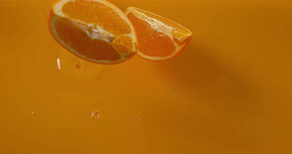 Orange, citrus sinensis, Fruit falling into Orange Juice, Slow Motion 4K alt
