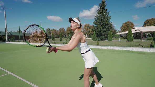 Pro Tennis Player Hits the Ball with a Racket Practice Game on the Tennis Court Female Serving Ball alt