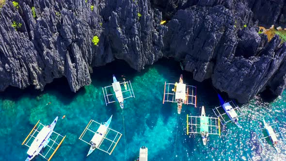 Aerial Drone View of Swimmers Inside a Tiny Hidden Tropical Lagoon Surrounded By Cliffs - Secret alt