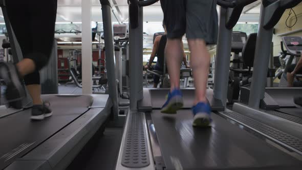 People running on treadmills at gym