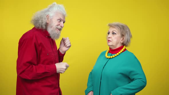 Cheerful Funny Senior Man Dancing As Shocked Woman Standing with Dazed Facial Expression Holding alt