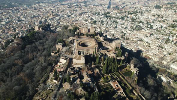 Drone circling pov of Charles V Palace inside Alhambra citadel with cityscape in background, Granada