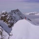 Aerial drone view of a mountain climber skier on the peak summit top of a snow covered mountain - VideoHive Item for Sale
