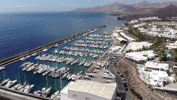 Aerial footage of the beautiful Boats and Boat Harbour Marina and pier taken in Lanzarote in Spain alt