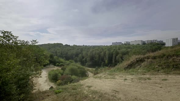 Rider On Sports Motorcycle Rides On Dirt Road He Goes Up The Hill And Makes Jump With Motorcycle alt
