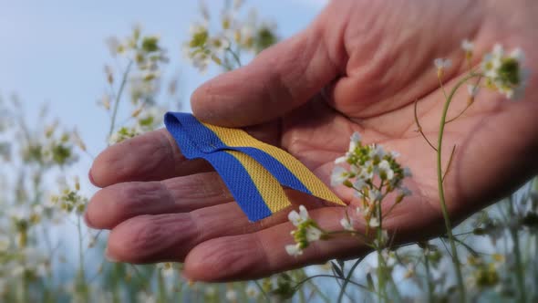 Closeup Shot of Someone Holding a Ukrainian Emblem in Nature