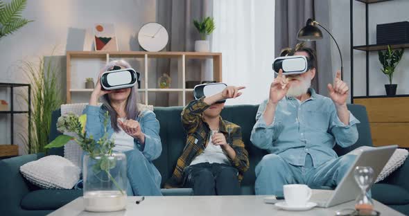 Modern Grandparent and their Grandson which Having Fun Using Virtual Reality Headset alt