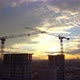 Aerial view of a multi-storey building under construction with construction cranes at sunset - VideoHive Item for Sale