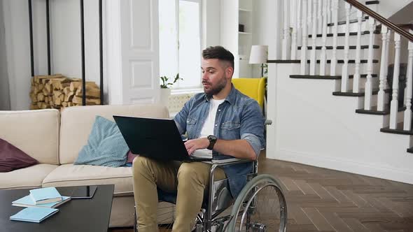 Bearded Guy in Wheelchair Having Video Call on Laptop with Relatives or Friends alt