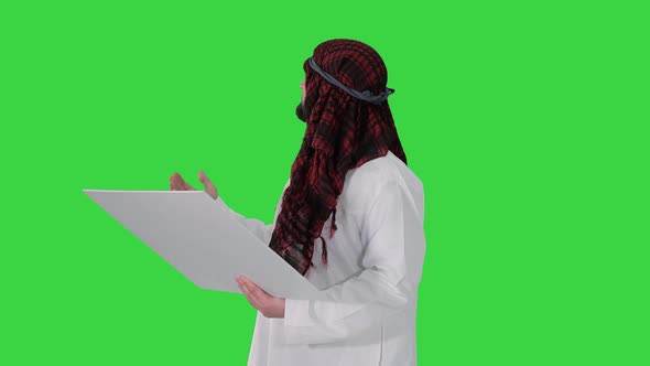 Sheikh Looking at Blueprint and at the Object on a Green Screen, Chroma Key. alt