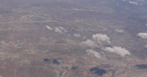 The View From the Plane of Fluffy Clouds in Desert Mountains From an Airplane New Mexico USA alt