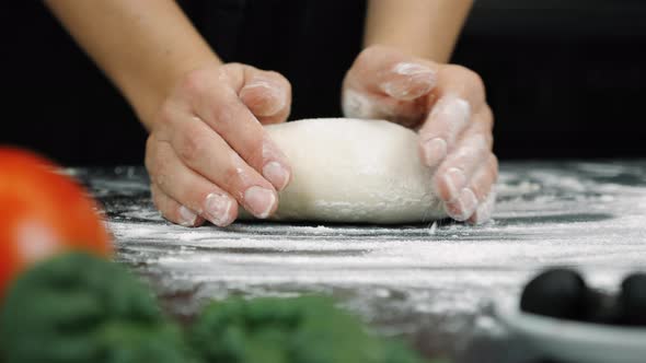 Hands knead raw dough, preparing bread alt