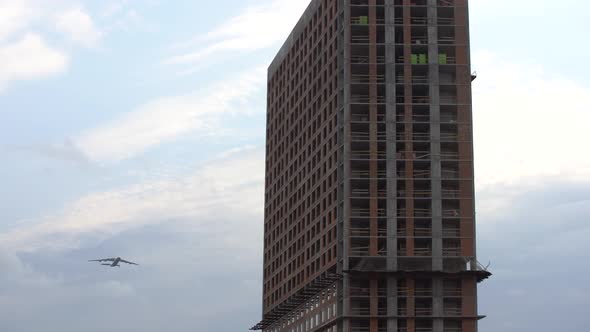 Low Angle Rotating Camera with a Airplane Flying Over the Top Big City Buildings