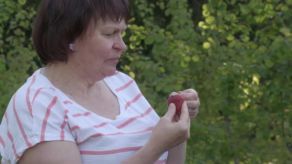Beautiful Shot of a Middleaged Lady Eating a Strawberry