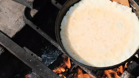 Cooking an Omelet on a Campfire in a Tourist Frying Pan in Nature alt