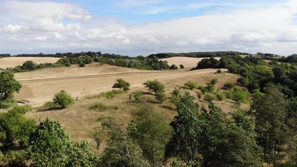 Aerial view of the coastline of Sejerøbugten with hills and trees. alt