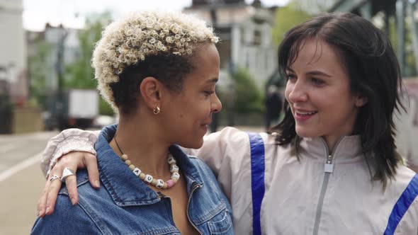 Affectionate lesbian couple talking in the street alt