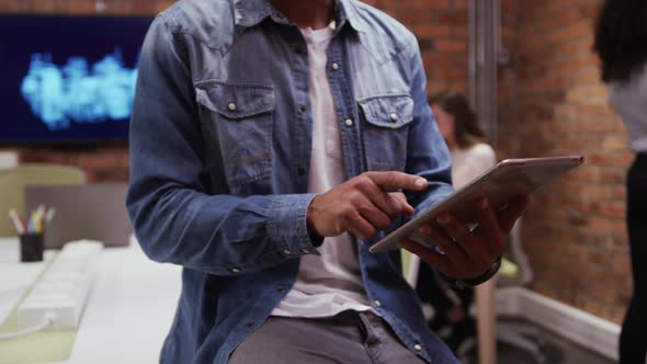 Mid section of creative businessman using digital tablet alt