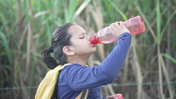 An Indian Boy Drinking Water From Bottle While Cycling Got Tired and Thirsty