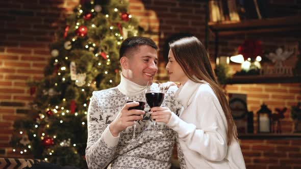 Couple Holding and Drinking Wine Glasses Sitting on Sofa Celebration Concept alt