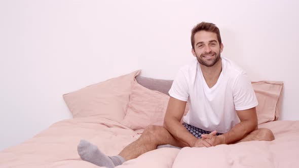 Smiling Guy Sitting On Bed